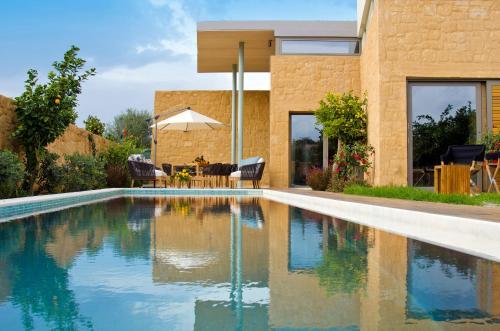 a swimming pool in front of a house at Conte Marino Villas in Maleme