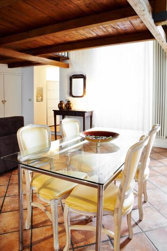 a dining room with a glass table and white chairs at P&P Piazza Bergamo Apartment in Bergamo