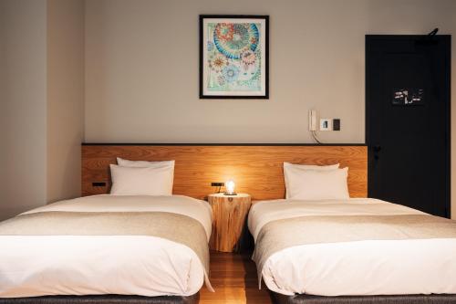 two beds sitting next to each other in a room at HOTEL KARUIZAWA CROSS in Karuizawa