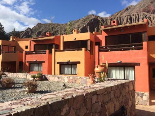 a building with a mountain in the background at Colores de Purmamarca in Purmamarca