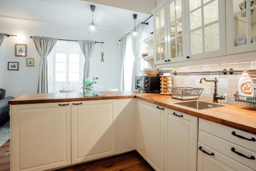 a kitchen with white cabinets and a sink at Strieborný dvor in Banská Štiavnica