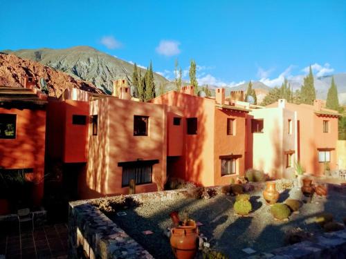 a group of buildings with mountains in the background at Colores de Purmamarca in Purmamarca