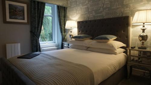 una camera da letto con un grande letto con cuscini e una finestra di Ivybank Lodge a Blairgowrie