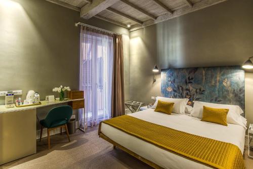 a bedroom with a bed and a desk and a window at Hotel Accademia in Rome