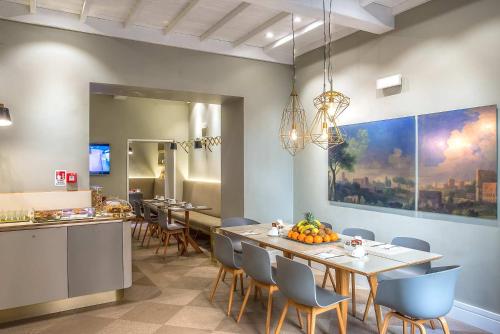 a kitchen with a table, chairs, and a large window at Hotel Accademia in Rome