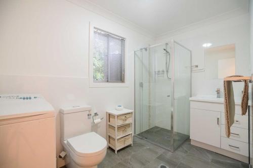 a bathroom with a toilet and a glass shower at Seabreeze Retreat in Point Clare