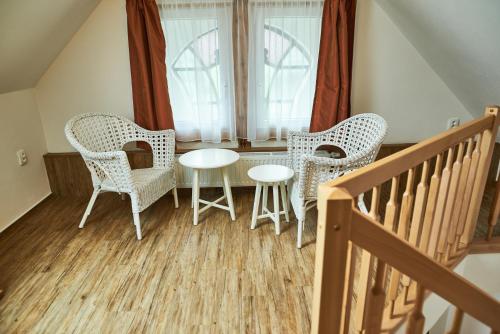 a table and chairs in a room with a window at Apartmány Na Faře in Bílá