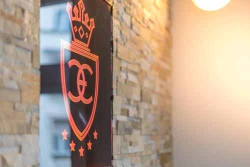 a sign on a brick wall with a royal crest at Enzo Capo Jacuzzi Andrassy in Budapest