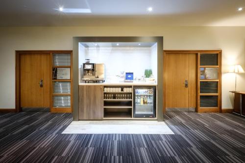 an empty room with a kitchen with a stove at Holiday Inn Coventry M6, J2 by IHG in Coventry