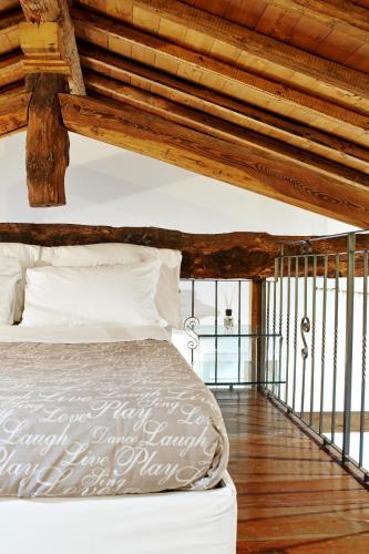 a bed in a room with a wooden ceiling at P&P Piazza Bergamo Apartment in Bergamo