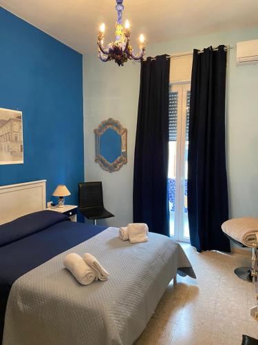 a blue bedroom with a bed and a chandelier at Casa Cristina in Maiori