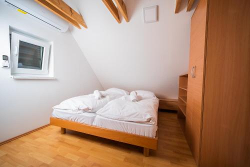 1 dormitorio pequeño con 1 cama con sábanas blancas en Villa Lara Terme Čatež 6 Thermal Riviera Tickets, en Čatež ob Savi