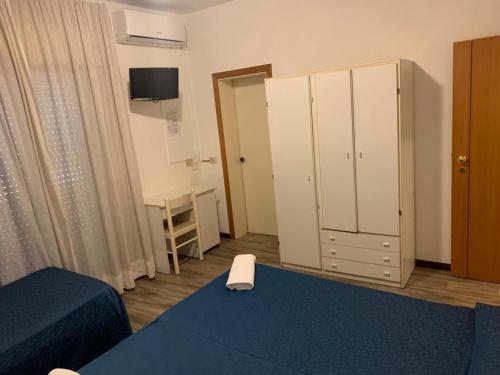 a room with a bedroom with a bed and a cabinet at Hotel Piada D'Oro in Riccione