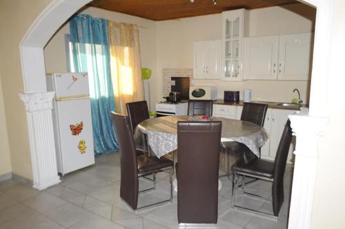 a kitchen with a table and chairs and a refrigerator at Résidence Hotelière Borel Denver in Douala