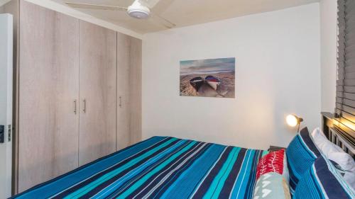 a bedroom with a bed and a painting on the wall at Ocean Breeze at 92 Chaka Cove in Ballito