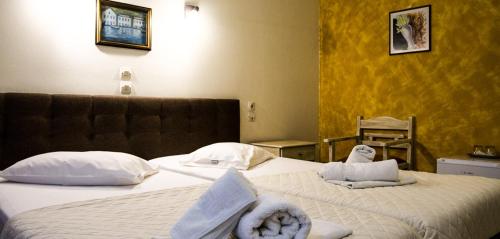 a hotel room with two beds with towels on them at Hotel Alos in Almirós
