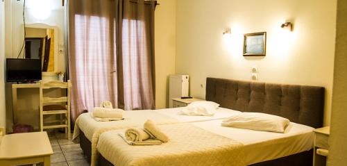 a hotel room with two beds with towels on them at Hotel Alos in Almirós