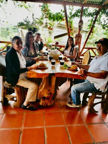 a group of people sitting around a wooden table at CABAÑA LOS NOGALES in San Agustín
