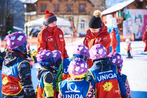 a group of children are standing in the snow at Apartmány Na Faře in Bílá