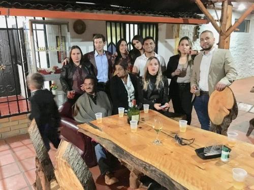 a group of people standing around a table at CABAÑA LOS NOGALES in San Agustín