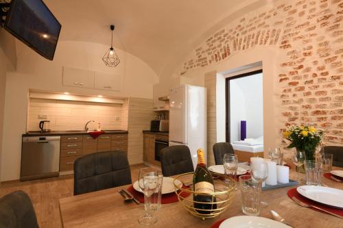 cocina y comedor con mesa y copas de vino en Apartmány Karina en Janske Lazne
