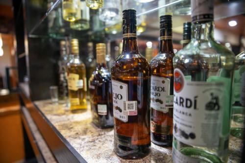 Un montón de botellas de alcohol sobre un mostrador. en Hotel San Martin, en Hermosillo