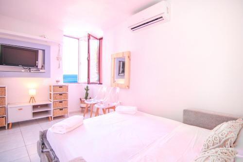 a white bedroom with a bed and a table and chairs at Apartamento Muralla Roja 0507 in Calpe