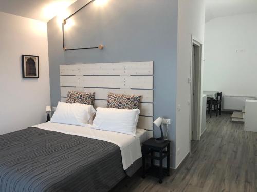 1 dormitorio con 1 cama grande con almohadas blancas en Locanda Monte San Giorgio, en Piossasco