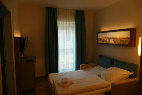 a bedroom with a bed and a window at Meyn's Apartments & Hotel in Soltau