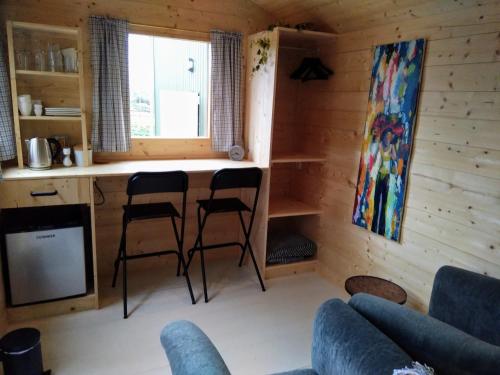 een woonkamer met 2 stoelen en een aanrecht in een hut bij Langs De Maas in Boxmeer