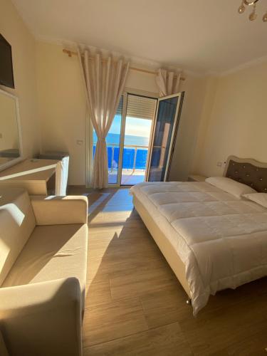 a bedroom with a large bed and a large window at Hotel 3 Vellezerit in Durrës