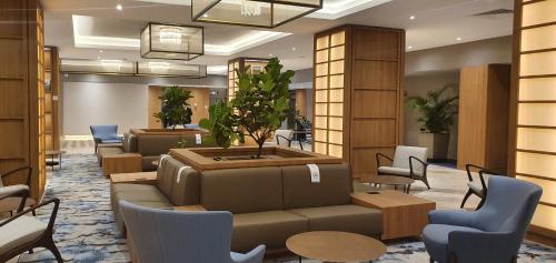 a lobby with a waiting area with chairs and a plant at Hotel Intercontinental Cali, an IHG Hotel in Cali