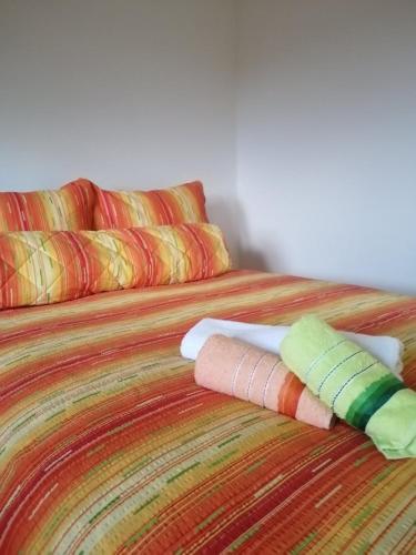a bed with colorful blankets and pillows on it at Uzicki-konaci in Užice