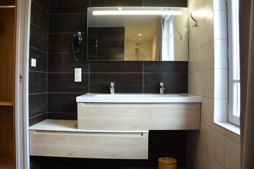 uma casa de banho com um lavatório e um espelho em une nuit sur le pont 1 em Landerneau