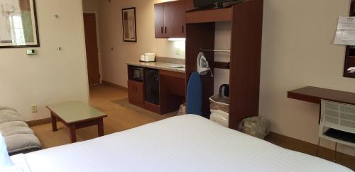 a small room with a bed and a kitchen at Microtel Inn & Suites by Wyndham Wellsville in Wellsville