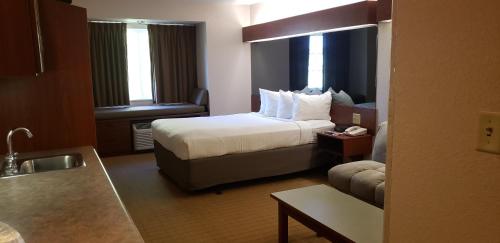 a hotel room with a bed and a couch at Microtel Inn & Suites by Wyndham Wellsville in Wellsville