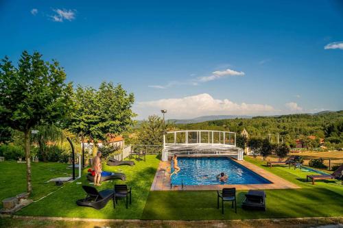 a pool with chairs and people playing in it at A Forxa Casa Ferrador Ribeira Sacra in Sober