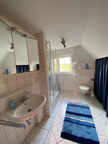 a bathroom with a sink and a shower and a toilet at Ferienwohnung am Deichweg in Cappel-Neufeld
