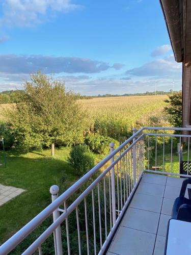 a balcony with a view of a field at Ferienwohnung am Deichweg in Cappel-Neufeld