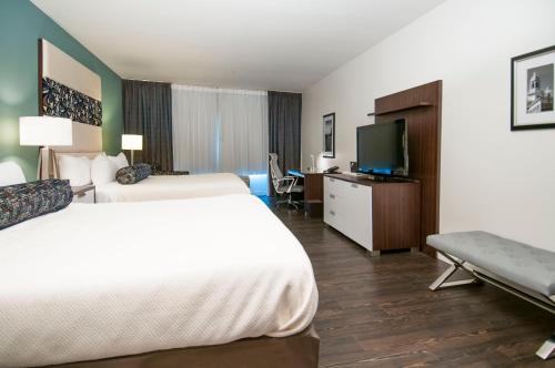 a hotel room with two beds and a flat screen tv at Hotel Indigo Waco by IHG in Waco