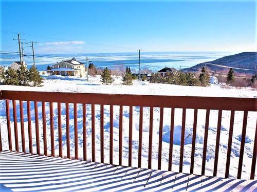 a wooden fence with snow on the ground at Maison Accueillante - Spa, fleuve et montagnes! in Petite-Rivière-Saint-François