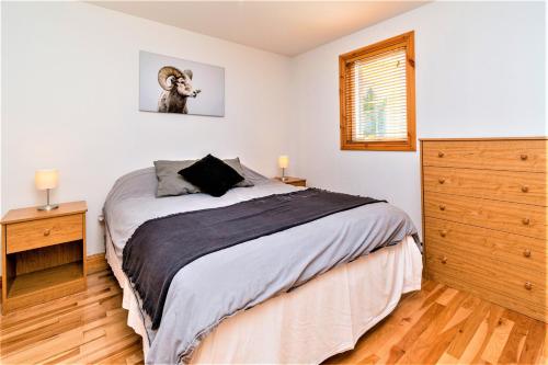 a bedroom with a bed with a dog on the wall at Maison Accueillante - Spa, fleuve et montagnes! in Petite-Rivière-Saint-François