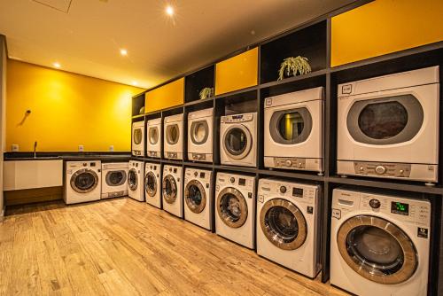 uma lavandaria com um monte de máquinas de lavar e secar em 360 Suítes Sé em São Paulo