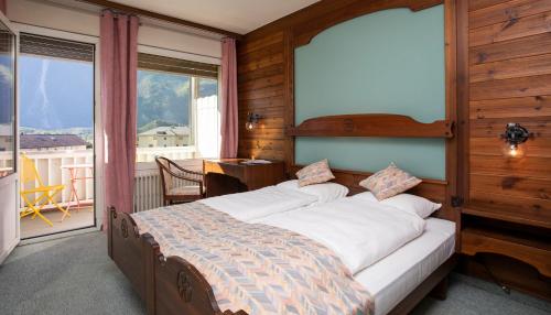 ein Schlafzimmer mit einem großen Bett vor einem Fenster in der Unterkunft Hôtel Art le Vin - Rhône in Salgesch