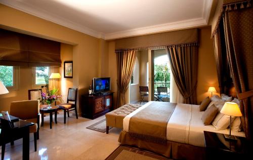 a hotel room with a large bed and a television at Stella Golf Hotel in Ain Sokhna