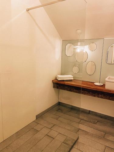 a bathroom with a counter and two mirrors on the wall at Les gîtes du Moulin castral in Geer