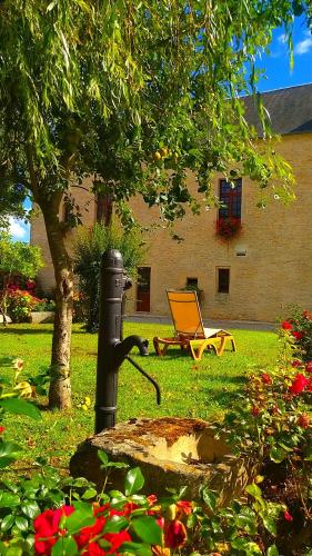 a fire hydrant and a chair in a yard at Hôtel Le Manoir De Mathan Crépon à la campagne 5 mn d'Arromanches et 10 mn de Bayeux in Crépon