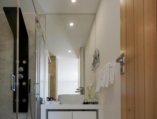 a bathroom with a sink and a shower at Portovella Lodges & Bungalows in Pala