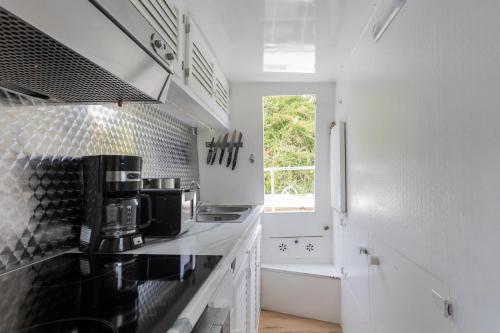 een keuken met witte muren en een zwart aanrecht bij Eucala motor yacht in East Molesey