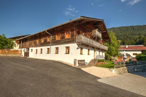 a large wooden building with a balcony on top of it at Chalet Rastenhof - Urlaub auf dem Bauernhof in Österreich in Gallzein